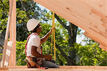 simsearch:6105-05396053,k - Carpenter measuring roof rafters Stock Photo - Premium Royalty-Free, Code: 6105-05396086