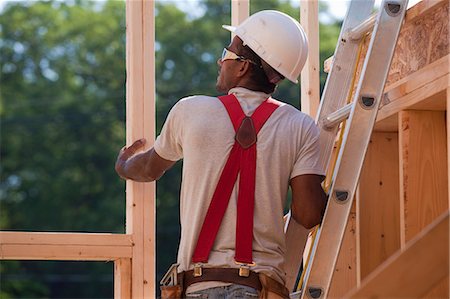 simsearch:6105-05396262,k - Hispanic carpenter on a ladder checking the framing of a house under construction Foto de stock - Royalty Free Premium, Número: 6105-05396005