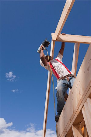 simsearch:6105-05396084,k - Low angle view of a carpenter nailing roof rafters Stock Photo - Premium Royalty-Free, Code: 6105-05396037