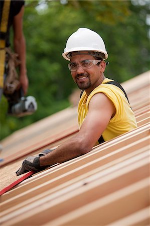 Hispanic carpenters placing roof panel at a house under construction Fotografie stock - Premium Royalty-Free, Codice: 6105-05396141