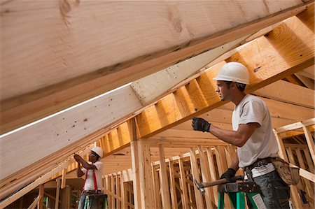 simsearch:6105-05396262,k - Hispanic carpenters working on roof rafters at a house under construction Foto de stock - Royalty Free Premium, Número: 6105-05396148