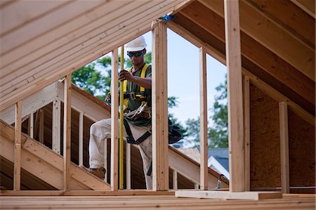 simsearch:6105-05396262,k - Hispanic carpenter measuring wall studs at a house under construction Foto de stock - Royalty Free Premium, Número: 6105-05396173