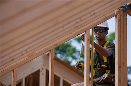 simsearch:6105-05396204,k - Hispanic carpenter measuring wall studs at a house under construction Stock Photo - Premium Royalty-Free, Code: 6105-05396174