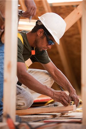 simsearch:6126-09267248,k - Hispanic carpenter marking a measurement on a board at a house under construction Foto de stock - Sin royalties Premium, Código: 6105-05396186