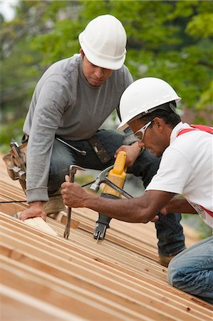 pied-de-biche - Charpentiers en utilisant un sawzall et pry bar sur le toit d'une maison en construction Photographie de stock - Premium Libres de Droits, Code: 6105-05396192