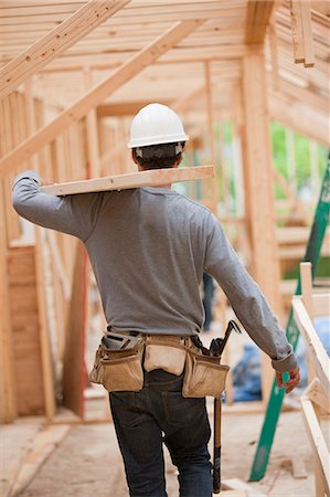 simsearch:6105-05396204,k - Hispanic carpenter carrying a board on the upper floor at a house under construction Stock Photo - Premium Royalty-Free, Code: 6105-05396199