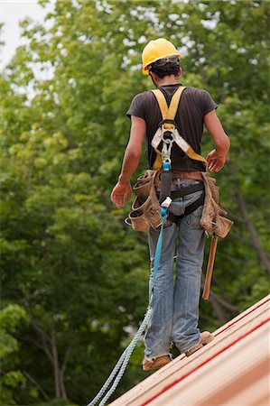 simsearch:6105-05396204,k - Hispanic carpenter walking on the roof construction of a house Stock Photo - Premium Royalty-Free, Code: 6105-05396117