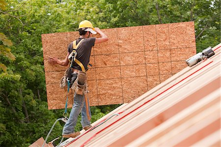 simsearch:6105-05396204,k - Hispanic carpenter carrying a particle board at a house under construction Stock Photo - Premium Royalty-Free, Code: 6105-05396119