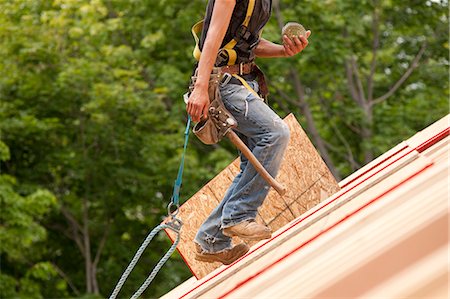 Hispanische Schreiner tragen Spulen der Nägel auf dem Dach eines Hauses im Bau Stockbilder - Premium RF Lizenzfrei, Bildnummer: 6105-05396120