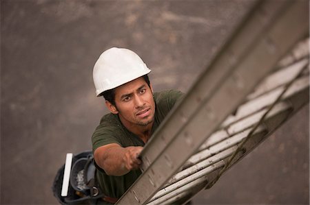 High angle view of a carpenter climbing a ladder at a construction site Foto de stock - Sin royalties Premium, Código: 6105-05396134