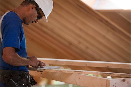 Hispanic carpenter measuring a rafter angle at a house under construction Stock Photo - Premium Royalty-Free, Code: 6105-05396254