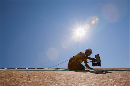 simsearch:6105-05396204,k - Hispanic carpenter using a nail gun on the roof of a house under construction Stock Photo - Premium Royalty-Free, Code: 6105-05396266