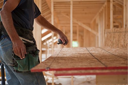 Charpentier hispanique claquer une ligne de chaîne sur un panneau de toit sur une maison en construction Photographie de stock - Premium Libres de Droits, Code: 6105-05396277