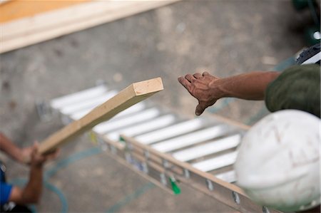 Hispanic carpenters lifting board at a house under construction Stock Photo - Premium Royalty-Free, Code: 6105-05396206