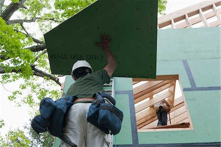 simsearch:6105-05396224,k - Hispanic carpenters taking wall sheathing up ladder at a house under construction Foto de stock - Sin royalties Premium, Código: 6105-05396224