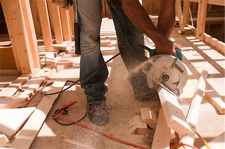 simsearch:6105-05396262,k - Hispanic carpenter using circular saw on board at a construction site Foto de stock - Royalty Free Premium, Número: 6105-05396237