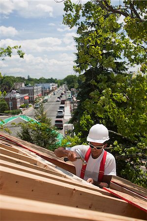 simsearch:6105-05396204,k - Hispanic carpenter hammering on roof window opening at a house under construction Stock Photo - Premium Royalty-Free, Code: 6105-05396239