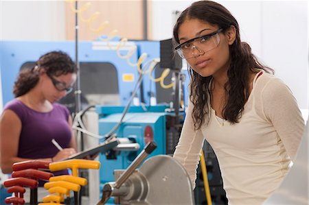 Engineering students working in a CNC machine lab Foto de stock - Sin royalties Premium, Código: 6105-05396369