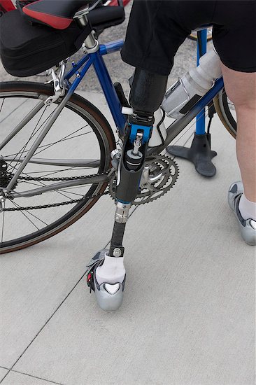 Woman with a prosthetic leg preparing for a bicycle race Stock Photo - Premium Royalty-Free, Image code: 6105-05396397