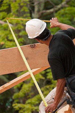 simsearch:6105-05396124,k - Charpentier hispanique mesurant un chevron avec un ruban à mesurer dans une maison en construction Photographie de stock - Premium Libres de Droits, Code: 6105-05396300