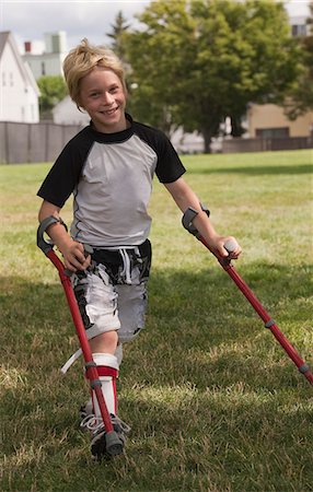 physical disability - Boy with cerebral palsy walking with the support of crutches Stock Photo - Premium Royalty-Free, Code: 6105-05396331