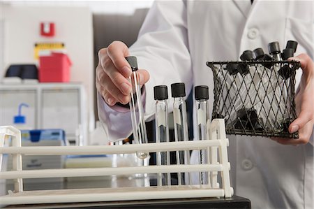 simsearch:6105-05396454,k - Scientist arranging test tubes in a rack in the laboratory of water treatment plant Stock Photo - Premium Royalty-Free, Code: 6105-05396451