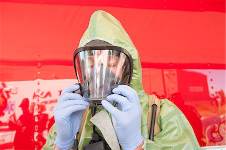 firefighter outdoors - Close-up of a HazMat firefighter putting on mask Foto de stock - Sin royalties Premium, Código: 6105-05396483