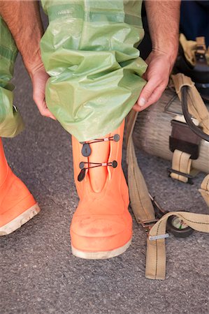 firefighter outdoors - HazMat firefighter putting on protective boots Foto de stock - Sin royalties Premium, Código: 6105-05396480