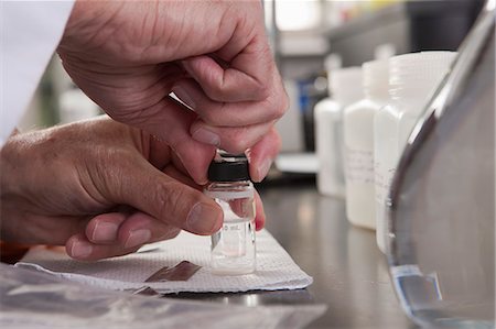 simsearch:6105-05396464,k - Scientist sealing sample bottles after adding chemicals in the laboratory of water treatment plant Foto de stock - Sin royalties Premium, Código: 6105-05396433