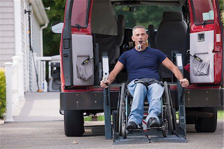 physical disability - Man with spinal cord injury in a wheelchair getting in his accessible van Stock Photo - Premium Royalty-Free, Code: 6105-05396583