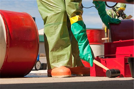 HazMat firefighter plugging a drum Foto de stock - Sin royalties Premium, Código: 6105-05396503