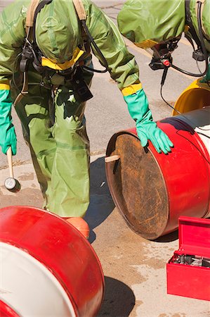 fire protection suit - HazMat firefighters plugging a drum Stock Photo - Premium Royalty-Free, Code: 6105-05396502