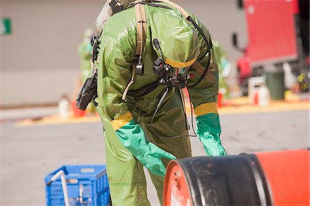 fire protection suit - HazMat firefighter plugging a drum Stock Photo - Premium Royalty-Free, Code: 6105-05396514