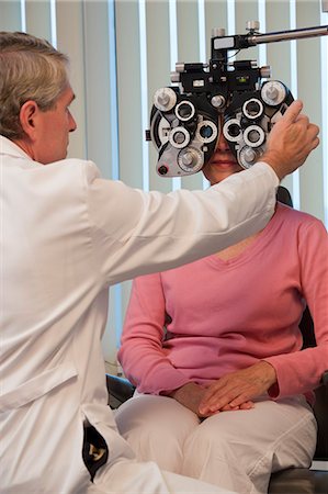 eye test - Ophthalmologist examining a woman's eyes with a phoropter Foto de stock - Sin royalties Premium, Código: 6105-05396640