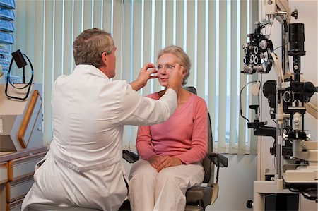 eye test - Ophthalmologist adjusting eyeglasses to a woman's eyes Stock Photo - Premium Royalty-Free, Code: 6105-05396642