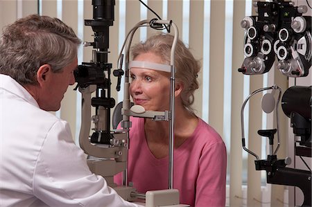 eye test - Ophthalmologist examining a woman's eyes with a slit lamp Stock Photo - Premium Royalty-Free, Code: 6105-05396647