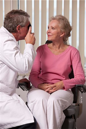 eye test - Ophthalmologist examining a woman's eyes with a direct ophthalmoscope Foto de stock - Sin royalties Premium, Código: 6105-05396644