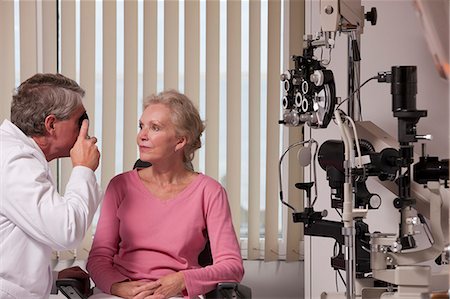 eye doctor test - Ophthalmologist examining a woman's eyes with a direct ophthalmoscope Stock Photo - Premium Royalty-Free, Code: 6105-05396645