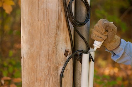 Engineer sealing cable entrance on wire duct at power pole Fotografie stock - Premium Royalty-Free, Codice: 6105-05396617