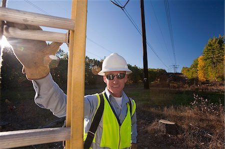 electric pylon - Engineer holding a ladder at power line location Foto de stock - Sin royalties Premium, Código: 6105-05396622