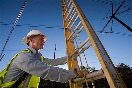 Engineer holding a ladder at power line location Stock Photo - Premium Royalty-Free, Code: 6105-05396624