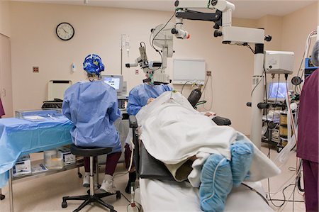 Surgery technologist handing instrument to doctor during cataract surgery Stock Photo - Premium Royalty-Free, Code: 6105-05396763