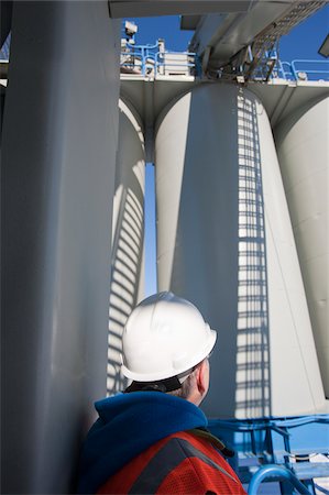 simsearch:6105-05396876,k - Engineer looking at storage silos at an industrial plant Stock Photo - Premium Royalty-Free, Code: 6105-05396853
