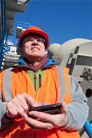 simsearch:6105-05396876,k - Engineer texting status on a mobile phone at materials plant in winter Stock Photo - Premium Royalty-Free, Code: 6105-05396859