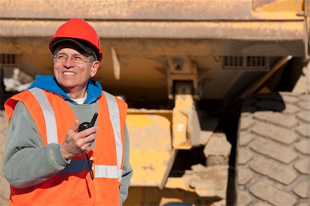 simsearch:6105-05396876,k - Engineer using a walkie-talkie in earth mover truck yard Stock Photo - Premium Royalty-Free, Code: 6105-05396882