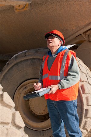 simsearch:6105-05396957,k - Engineer inspecting an earth mover Foto de stock - Royalty Free Premium, Número: 6105-05396884