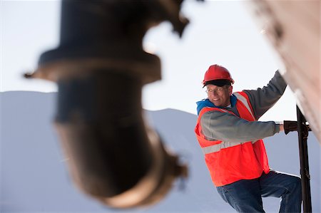 simsearch:6105-05396876,k - Engineer climbing the ladder of tanker truck Stock Photo - Premium Royalty-Free, Code: 6105-05396888