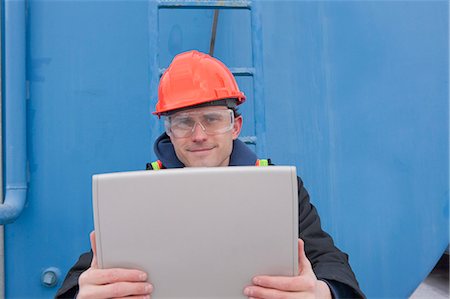 Engineer recording data on a laptop near a fuel tanker Fotografie stock - Premium Royalty-Free, Codice: 6105-05396978