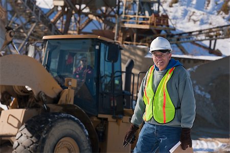 dump truck - Engineer with a walkie-talkie and front end loader at a construction site Foto de stock - Sin royalties Premium, Código: 6105-05396906