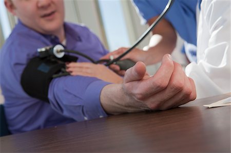 pressure - Female doctor and nurse measuring a patient's blood pressure Stock Photo - Premium Royalty-Free, Code: 6105-05397043